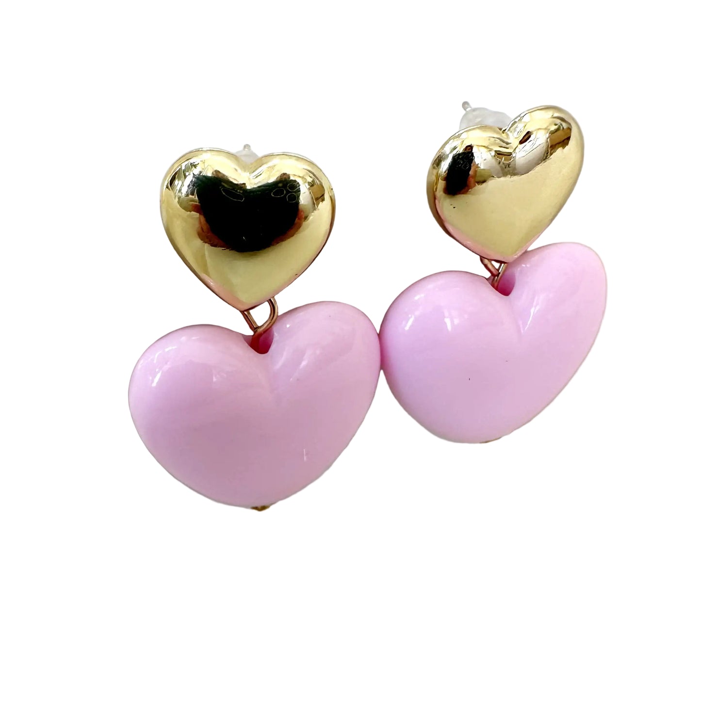 Heart-shaped earrings with gold top and pink bottom on a white stand.